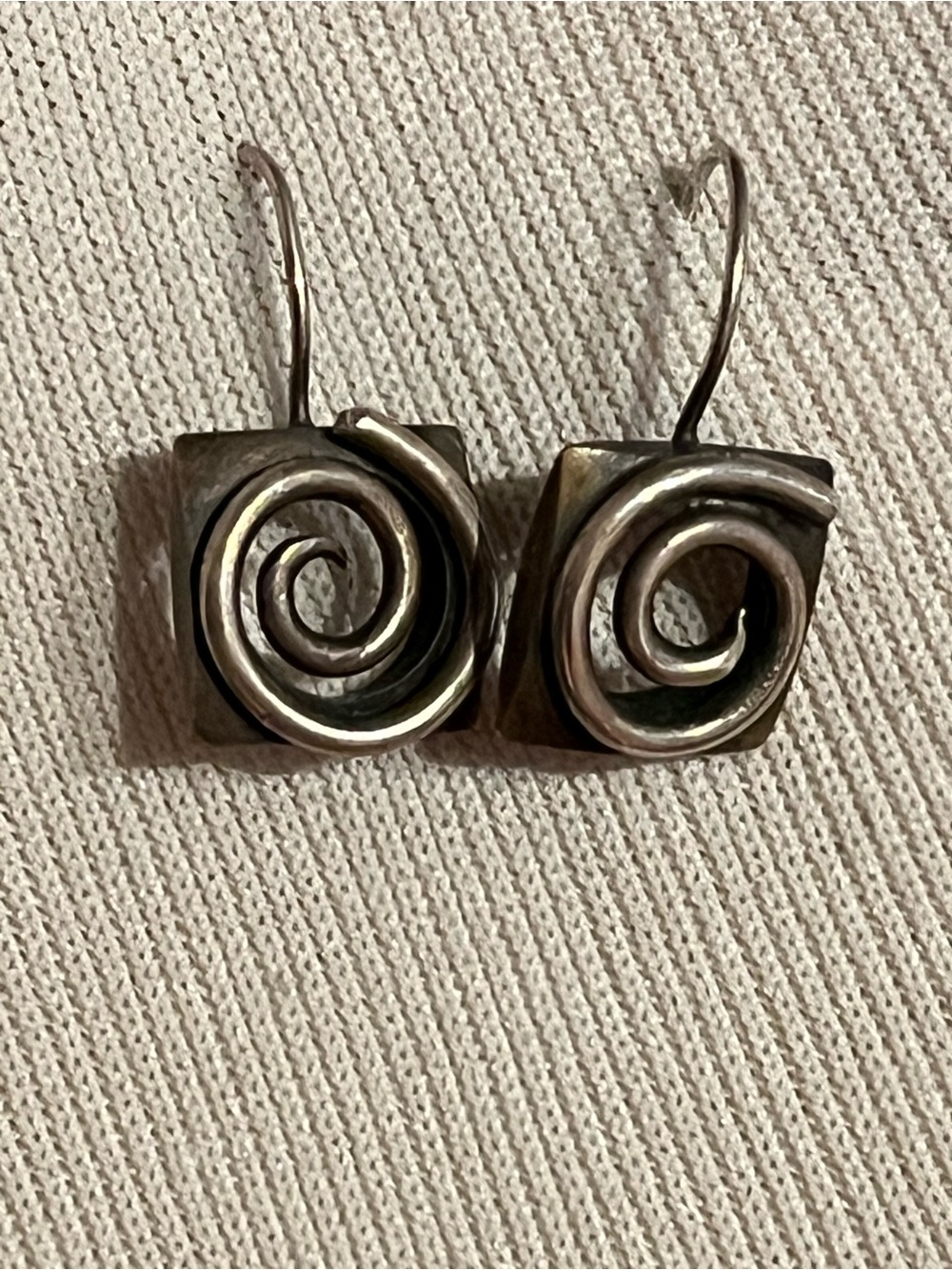 Women’s metal wire earrings.  Scroll design on a square base.